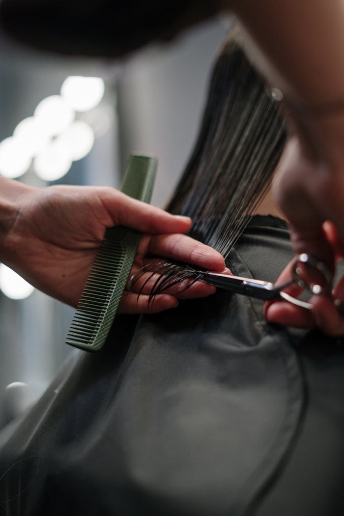 About Close-up of hairstylist cutting wet hair in a salon.